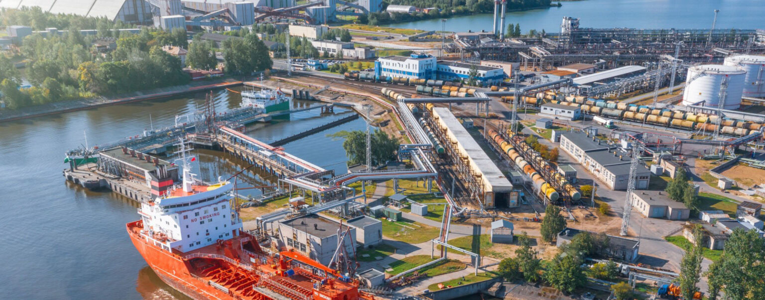 Aerial view large port with railway infrastructure for the delivery of bulk cargo by sea, loading oil using a pump station in ship tanker for transportation and delivery